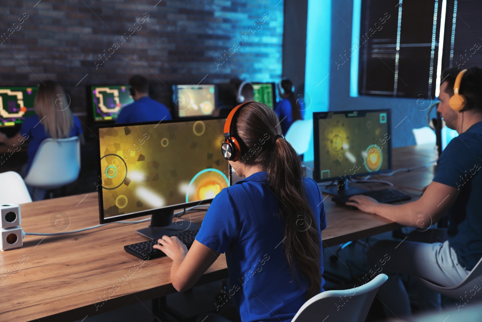 Photo of Group of people playing video games in internet cafe