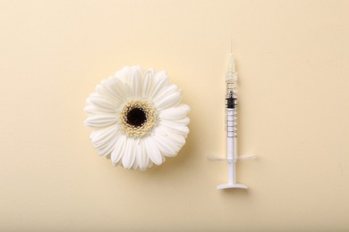 Photo of Cosmetology. Medical syringe and gerbera flower on yellow background, flat lay