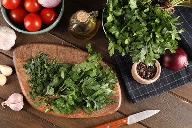 Fresh green parsley and different products on wooden table, flat lay