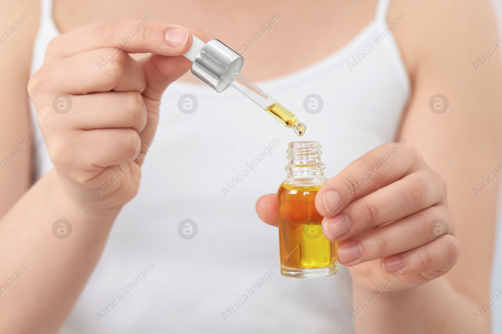 Photo of Woman with bottle of essential oil, closeup