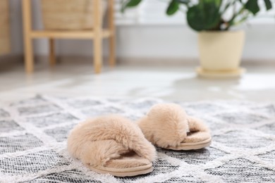 Photo of Beige soft slippers on carpet indoors, closeup