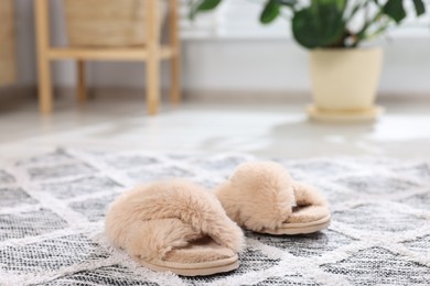 Beige soft slippers on carpet indoors, closeup