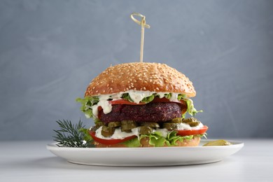 Photo of Vegetarian burger with delicious patty on white table