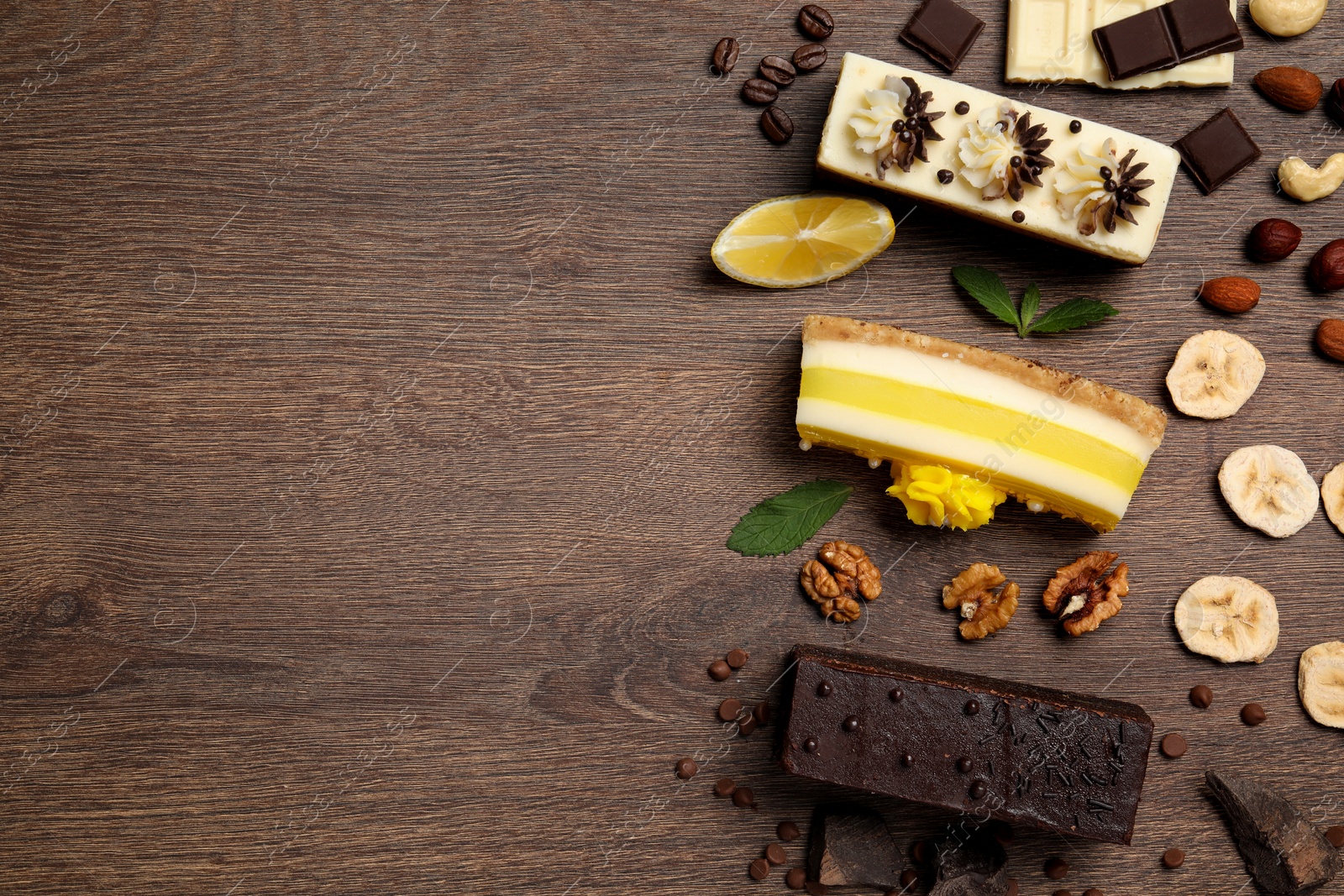 Photo of Flat lay composition with different tasty cakes on wooden table. Space for text