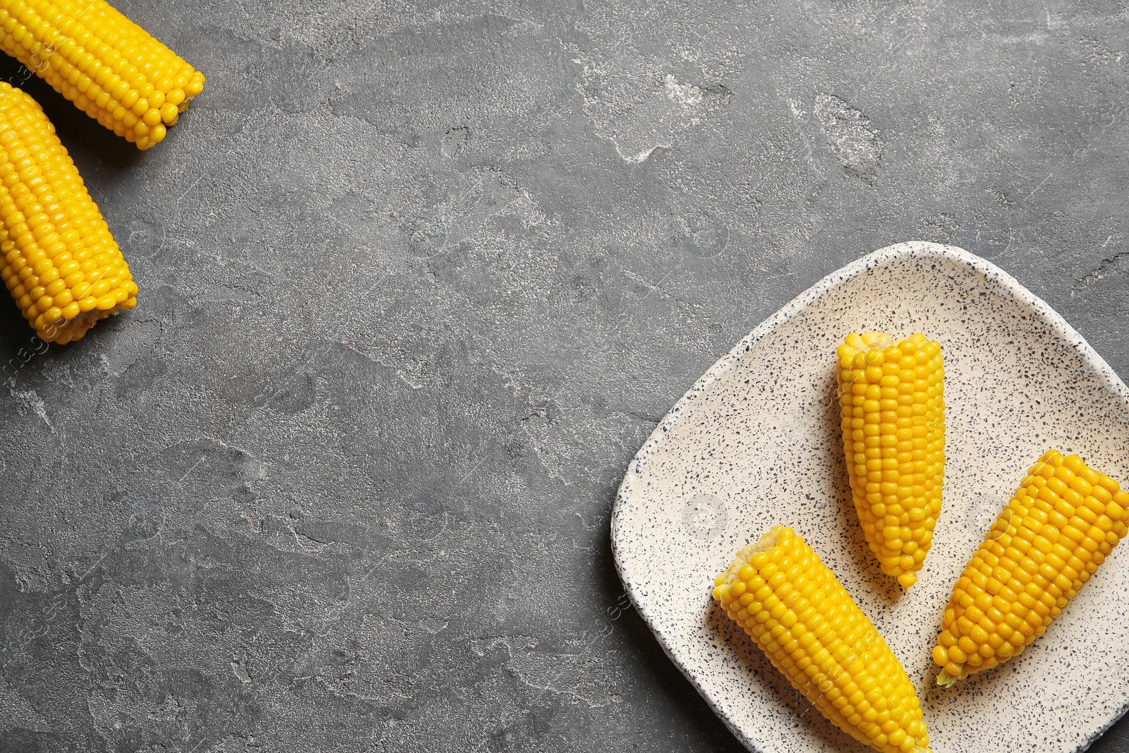 Photo of Flat lay composition with corn cobs on grey background. Space for text