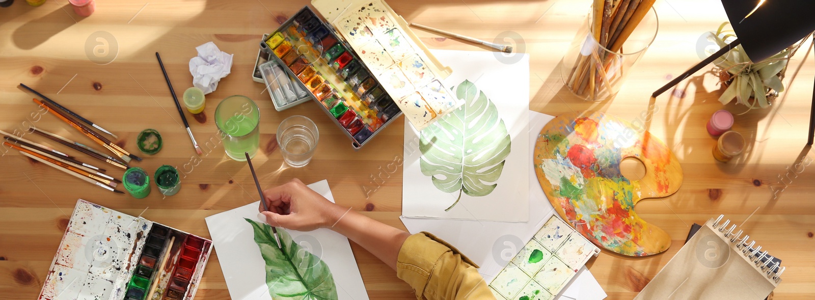 Image of Young woman drawing at table indoors, top view. Banner design