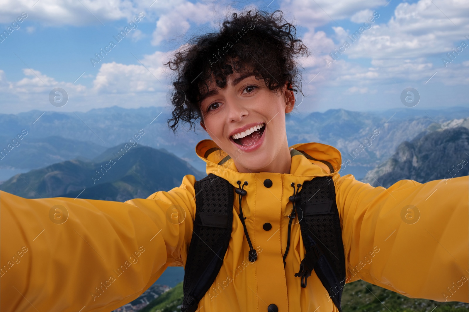 Image of Happy woman taking selfie in beautiful mountains