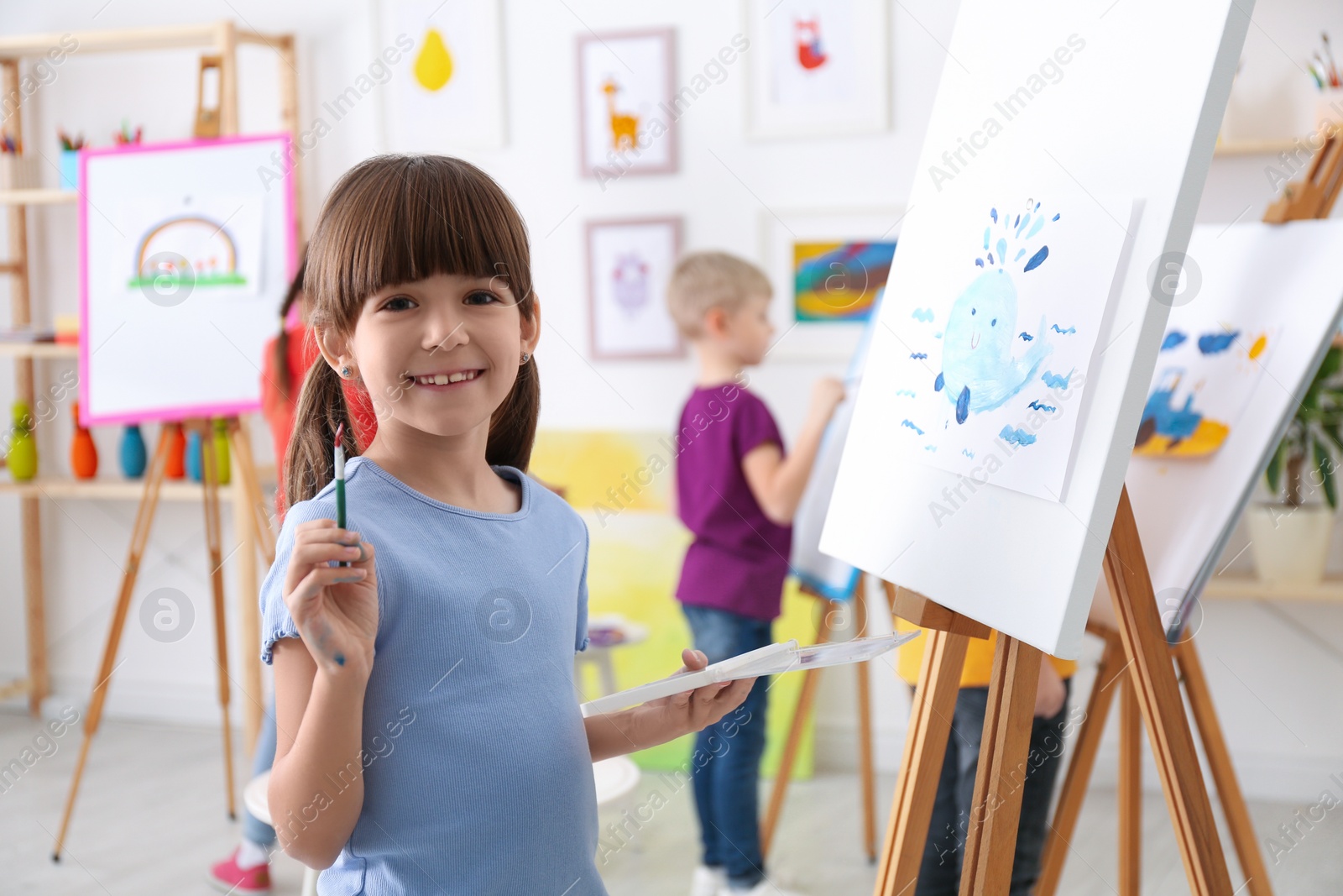 Photo of Cute little child painting during lesson in room