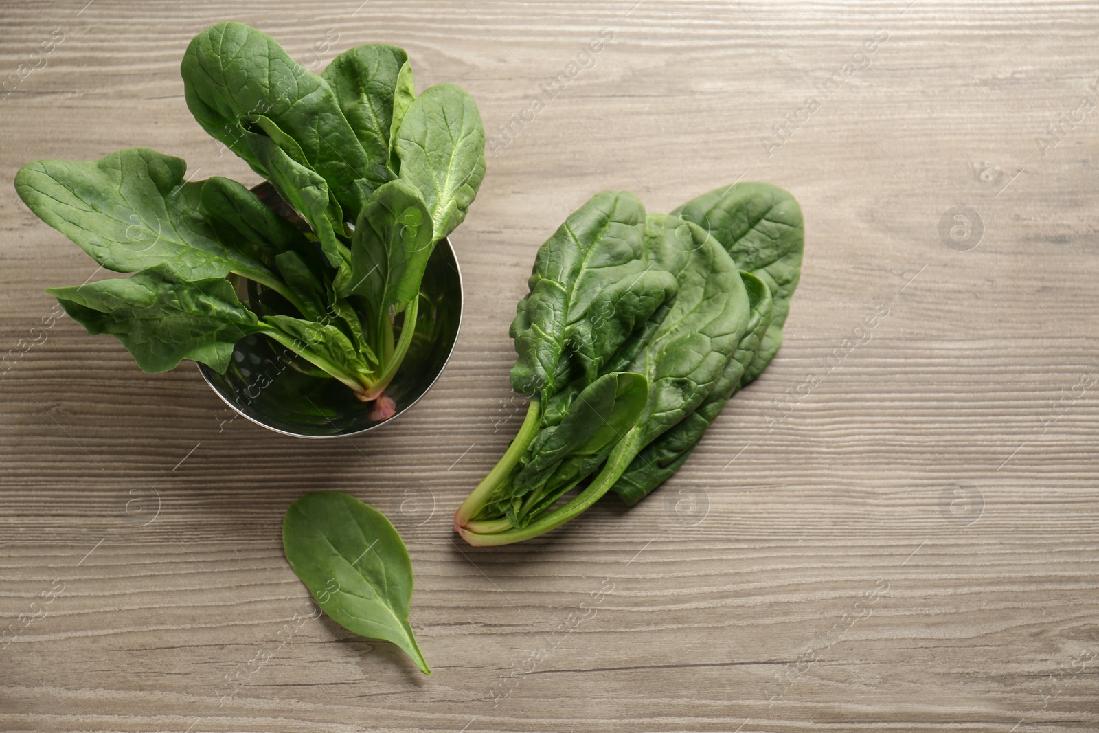 Photo of Fresh green healthy spinach leaves on wooden table, flat lay