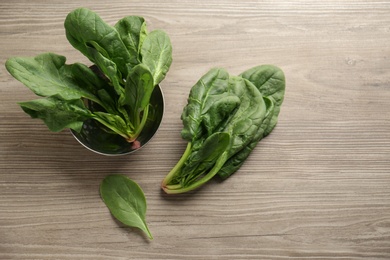 Photo of Fresh green healthy spinach leaves on wooden table, flat lay