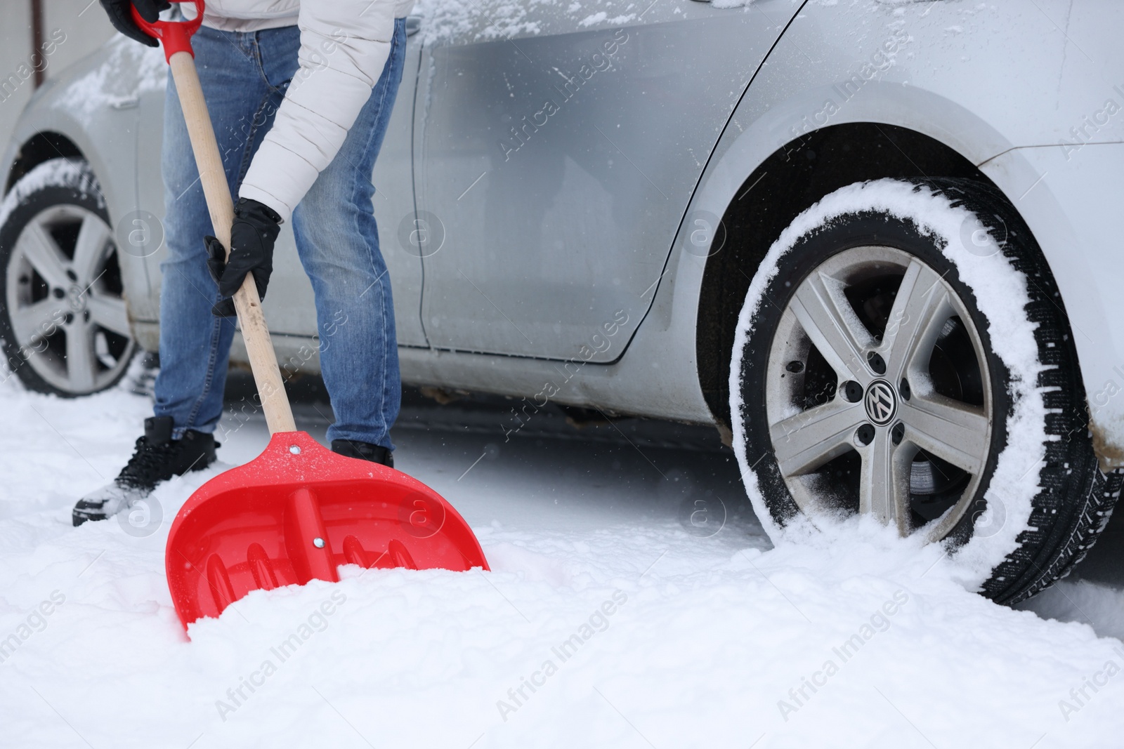 Photo of Man removing snow with shovel near car outdoors, closeup