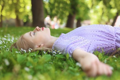 Photo of Beautiful woman lying on green grass in park. Spring sunny day