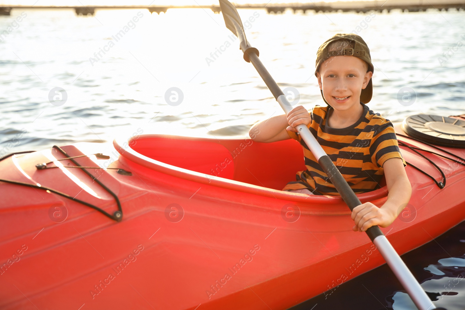 Photo of Happy little boy kayaking on river. Summer camp activity