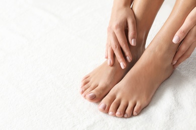 Woman with beautiful feet on white towel, closeup. Spa treatment