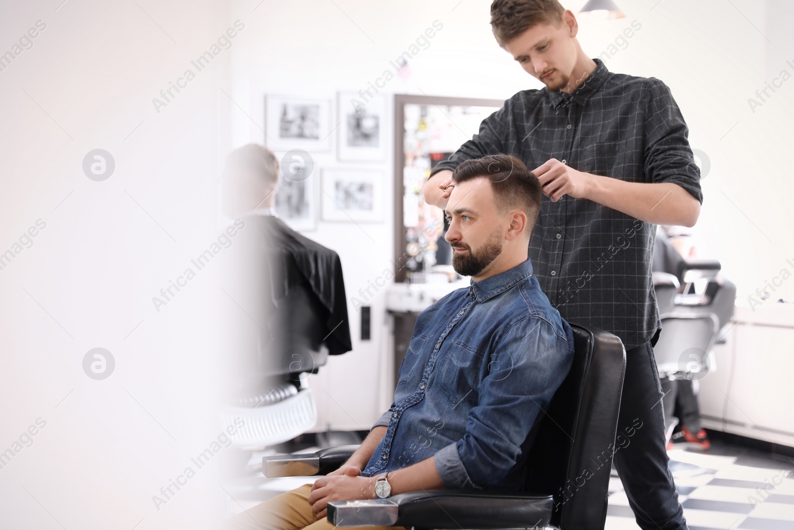 Photo of Professional barber working with client in hairdressing salon. Hipster fashion