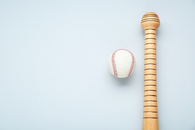 Photo of Wooden baseball bat and ball on light grey background, flat lay. Space for text