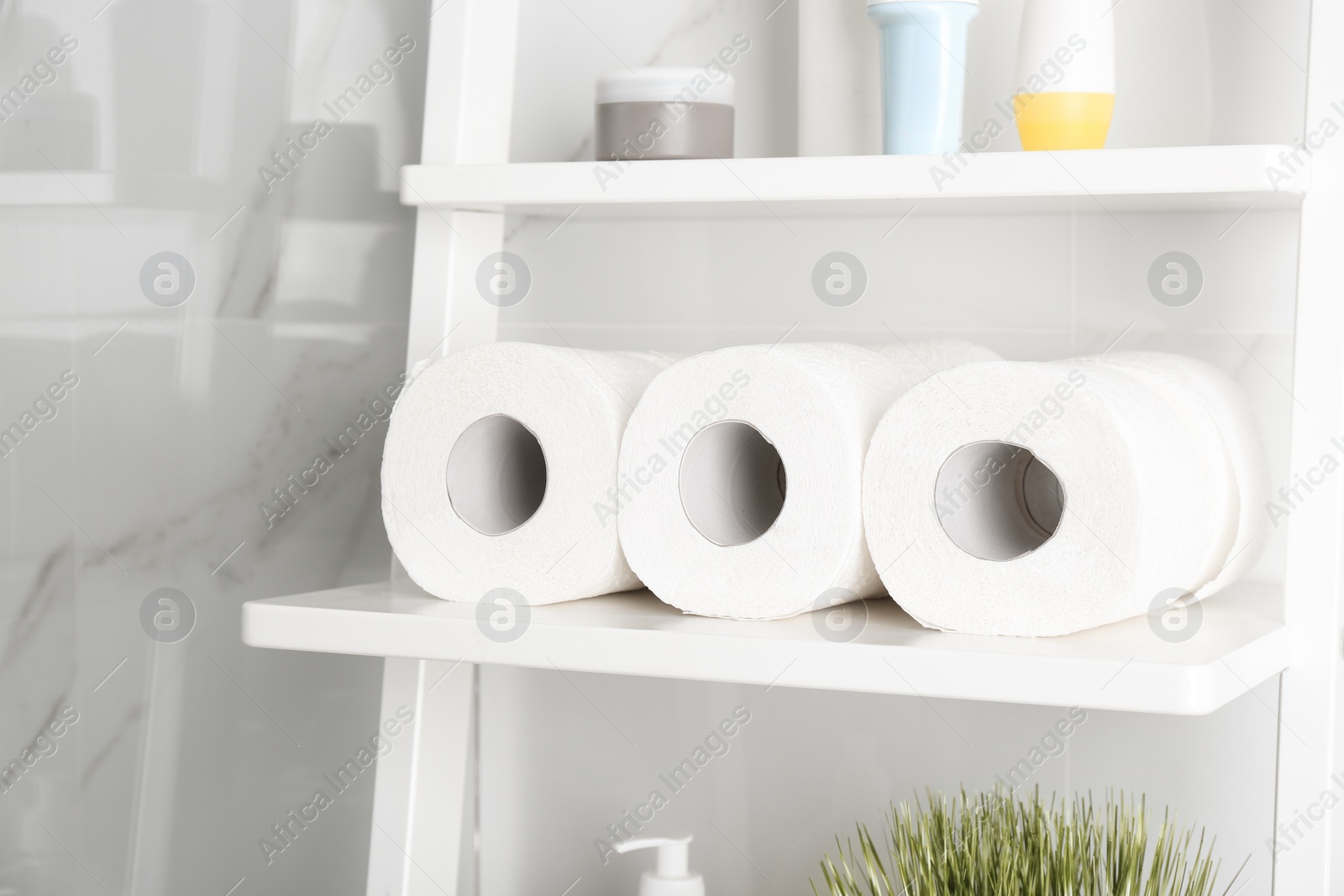 Photo of Toilet paper rolls on shelving unit in bathroom