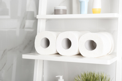 Photo of Toilet paper rolls on shelving unit in bathroom