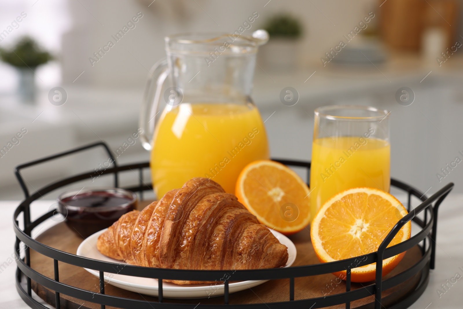 Photo of Breakfast time. Fresh croissant, jam and orange juice in tray