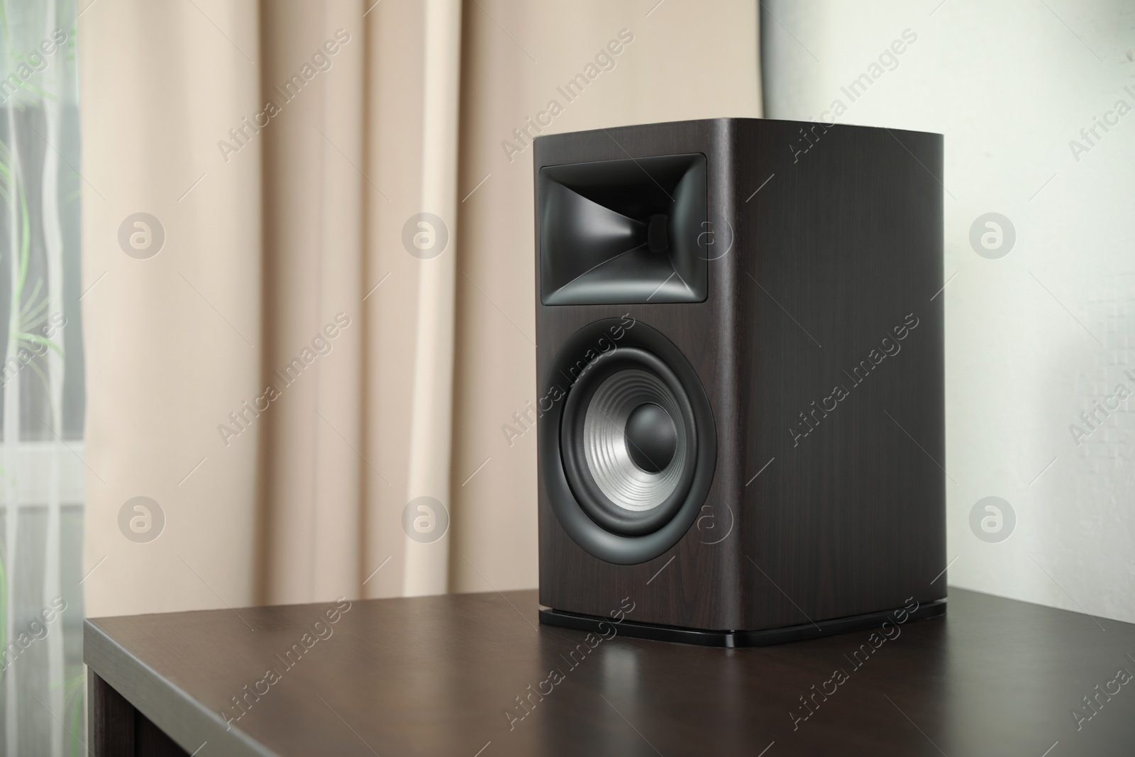 Photo of One sound speaker on table indoors. Space for text