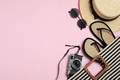 Flat lay composition with stylish beach accessories on pink background, space for text