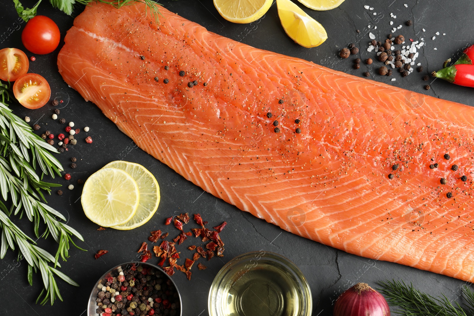 Photo of Fresh raw salmon and ingredients for marinade on black table, flat lay