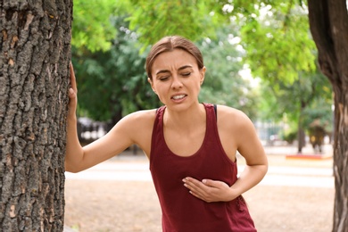 Young woman having heart attack while running in park