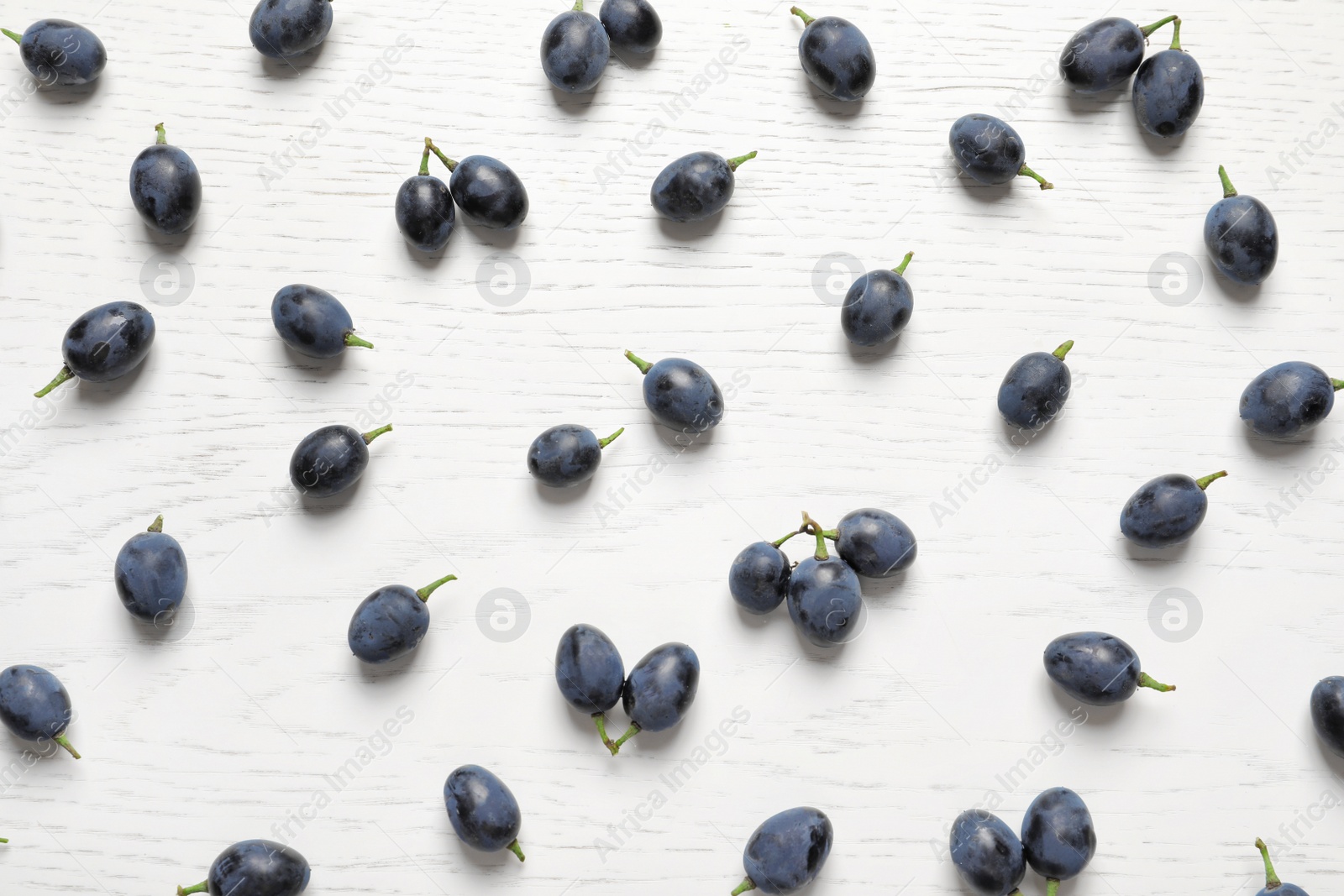 Photo of Fresh ripe juicy grapes on white wooden background, top view