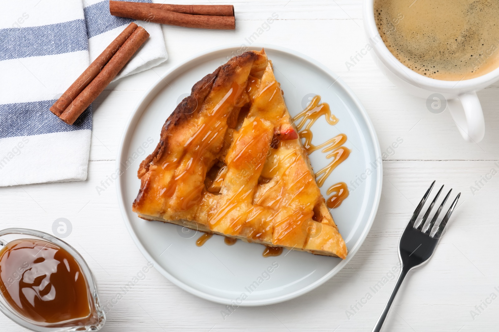 Photo of Slice of traditional apple pie served with coffee on white wooden table, flat lay