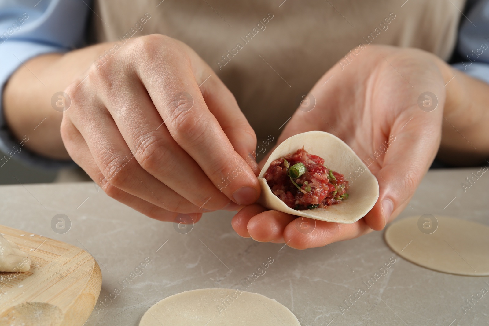 Photo of Woman making gyoza at light table, closeup