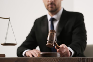 Law and justice. Closeup of judge with gavel at wooden table, selective focus