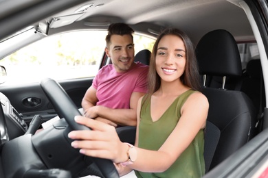 Happy young couple in car on road trip