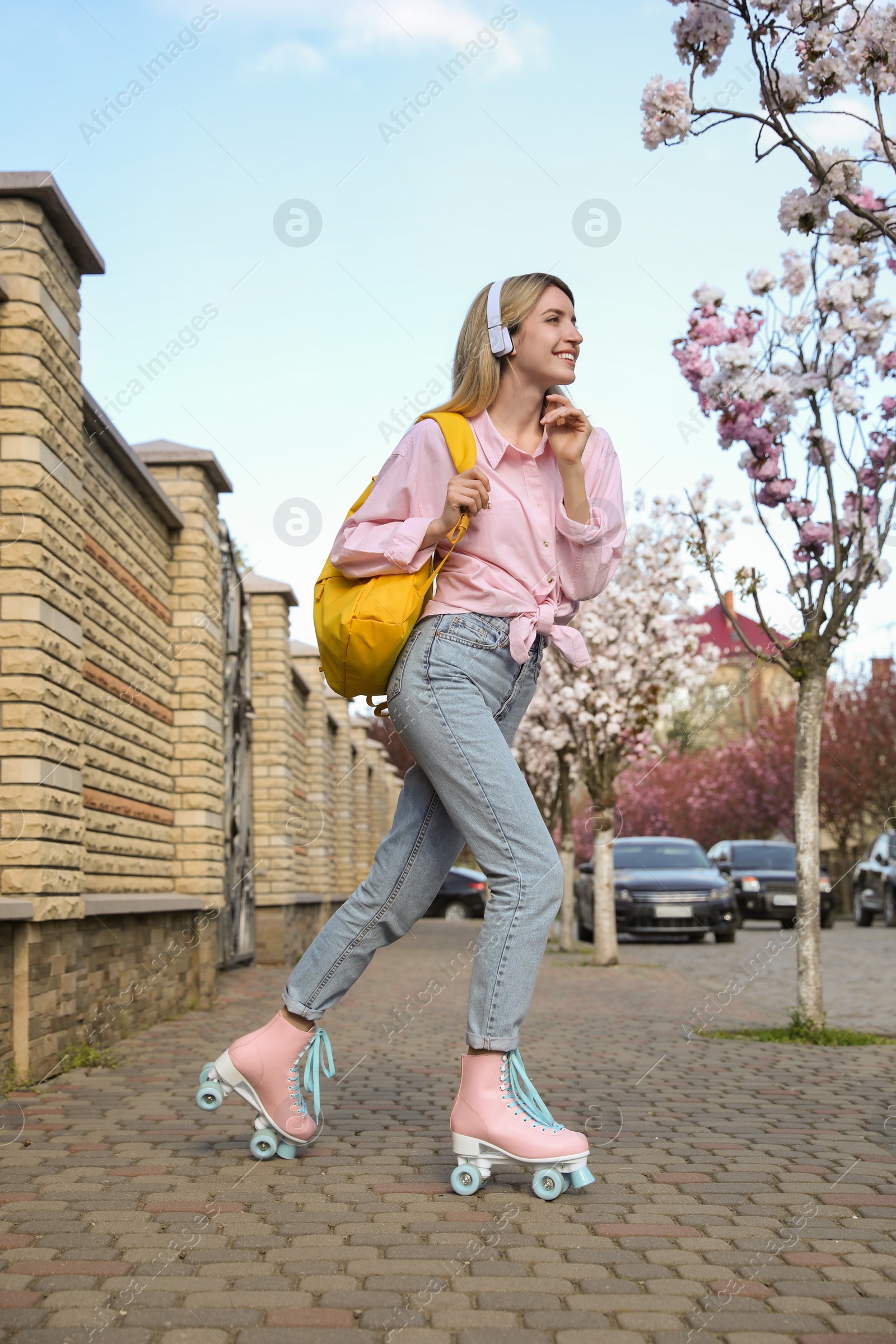 Photo of Young woman roller skating on city street