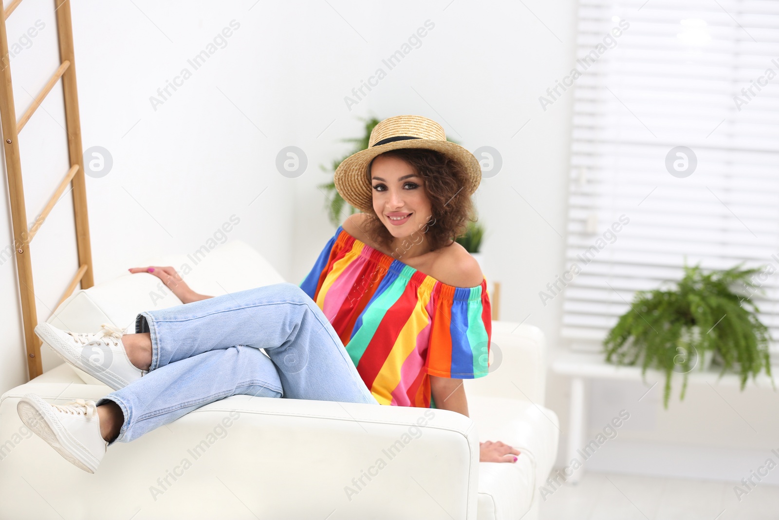 Photo of Beautiful woman in casual outfit on sofa indoors