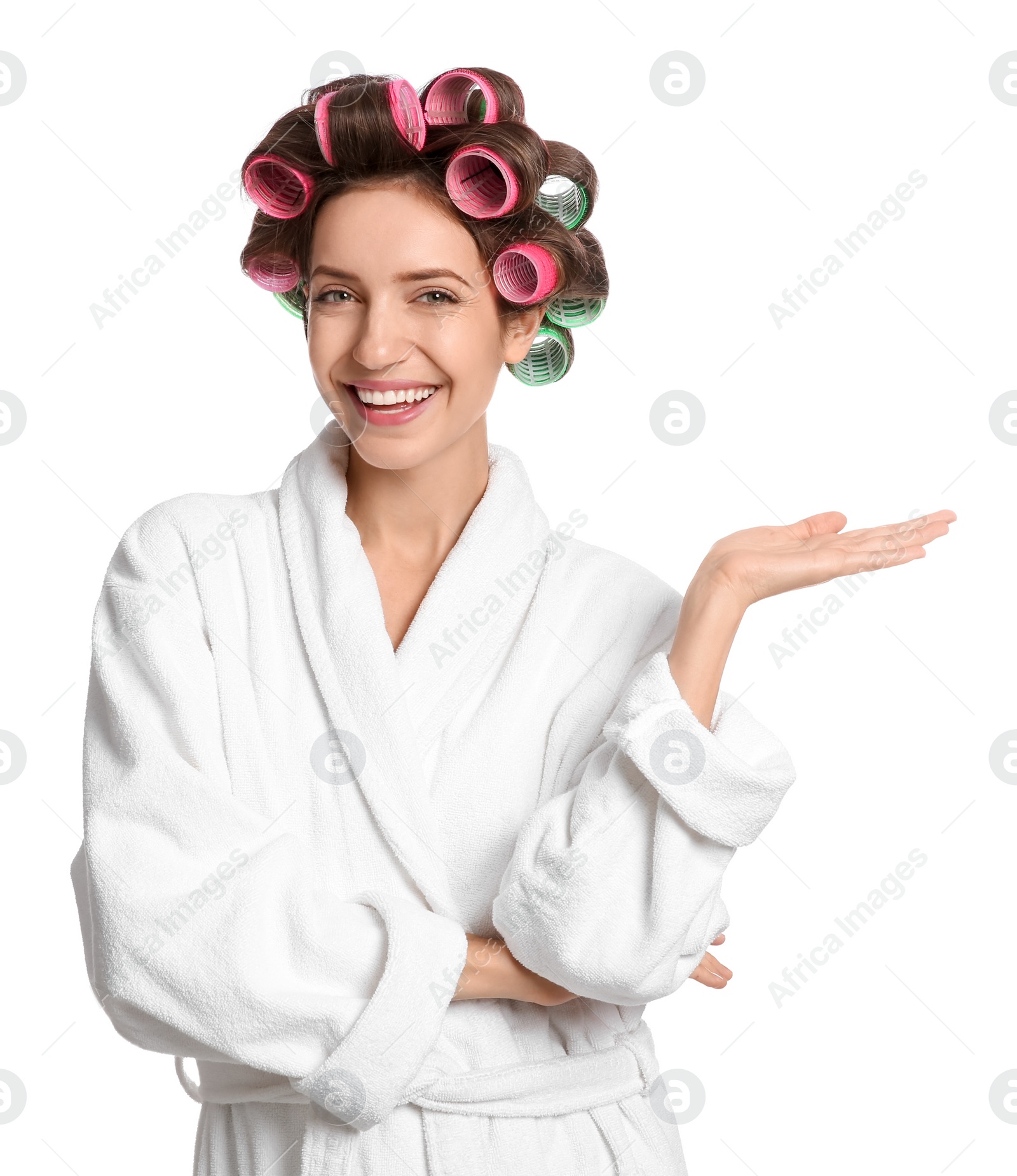 Photo of Beautiful young woman in bathrobe with hair curlers on white background