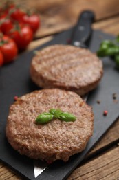 Photo of Tasty grilled hamburger patties served on wooden table, closeup