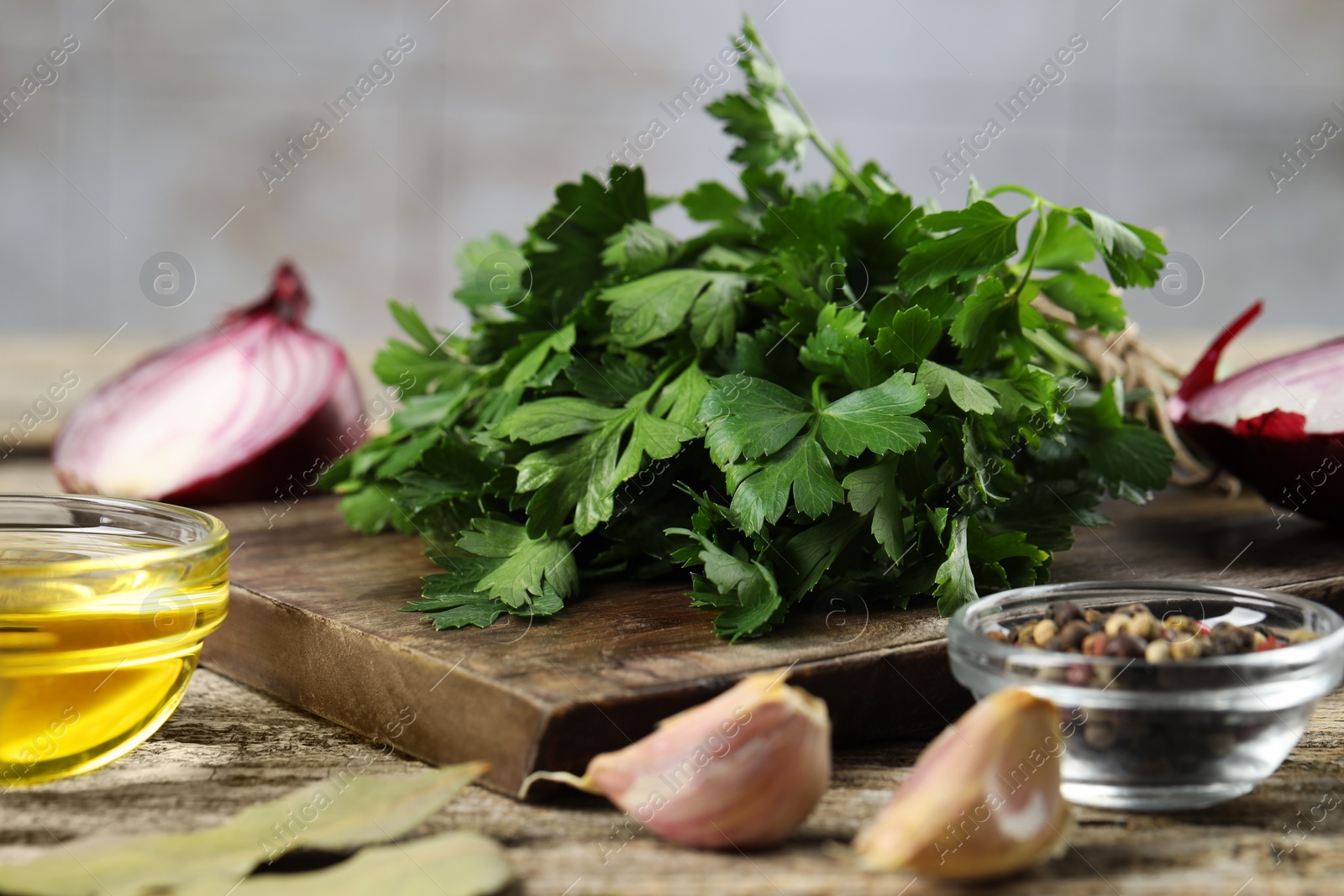 Photo of Board with fresh parsley, spices and other products on wooden table, closeup