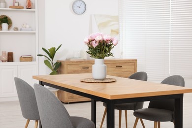 Stylish dining room with cosy furniture and flowers