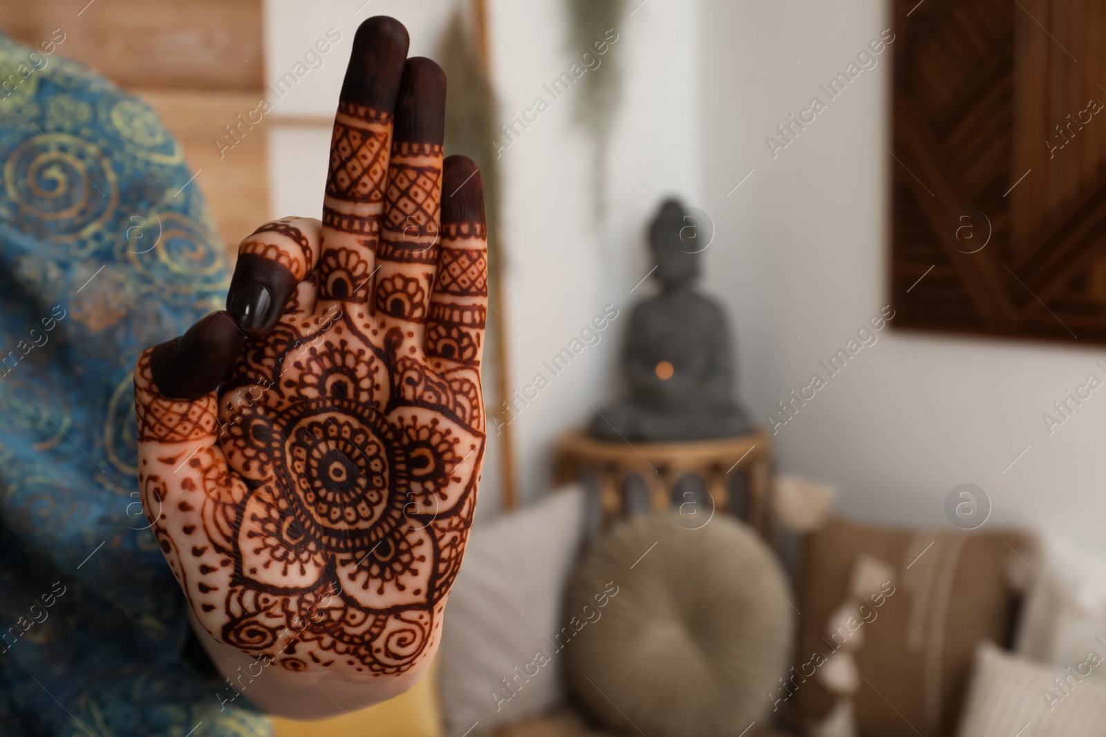 Photo of Woman with henna tattoo on palm indoors, closeup and space for text. Traditional mehndi ornament
