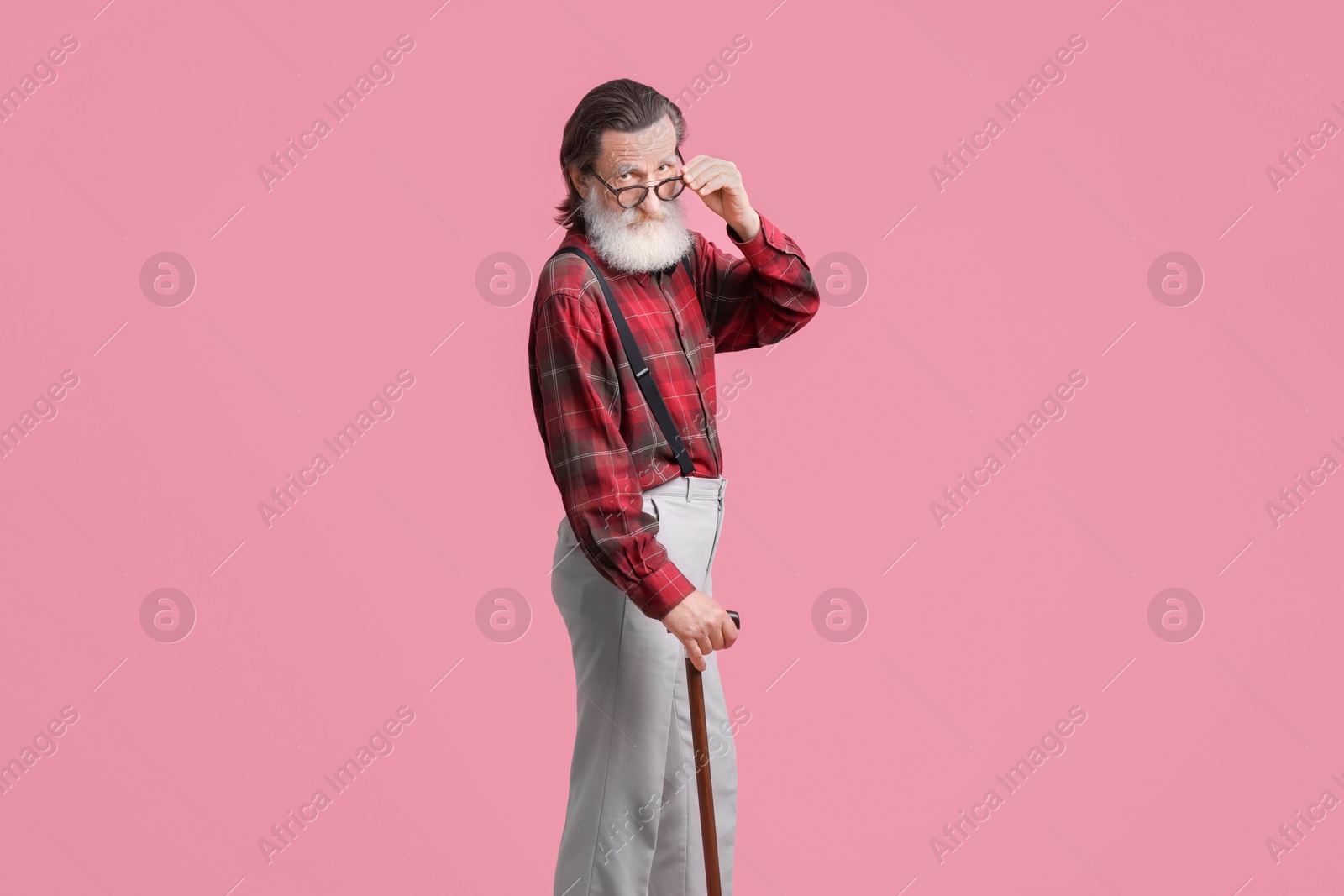 Photo of Senior man with walking cane on pink background