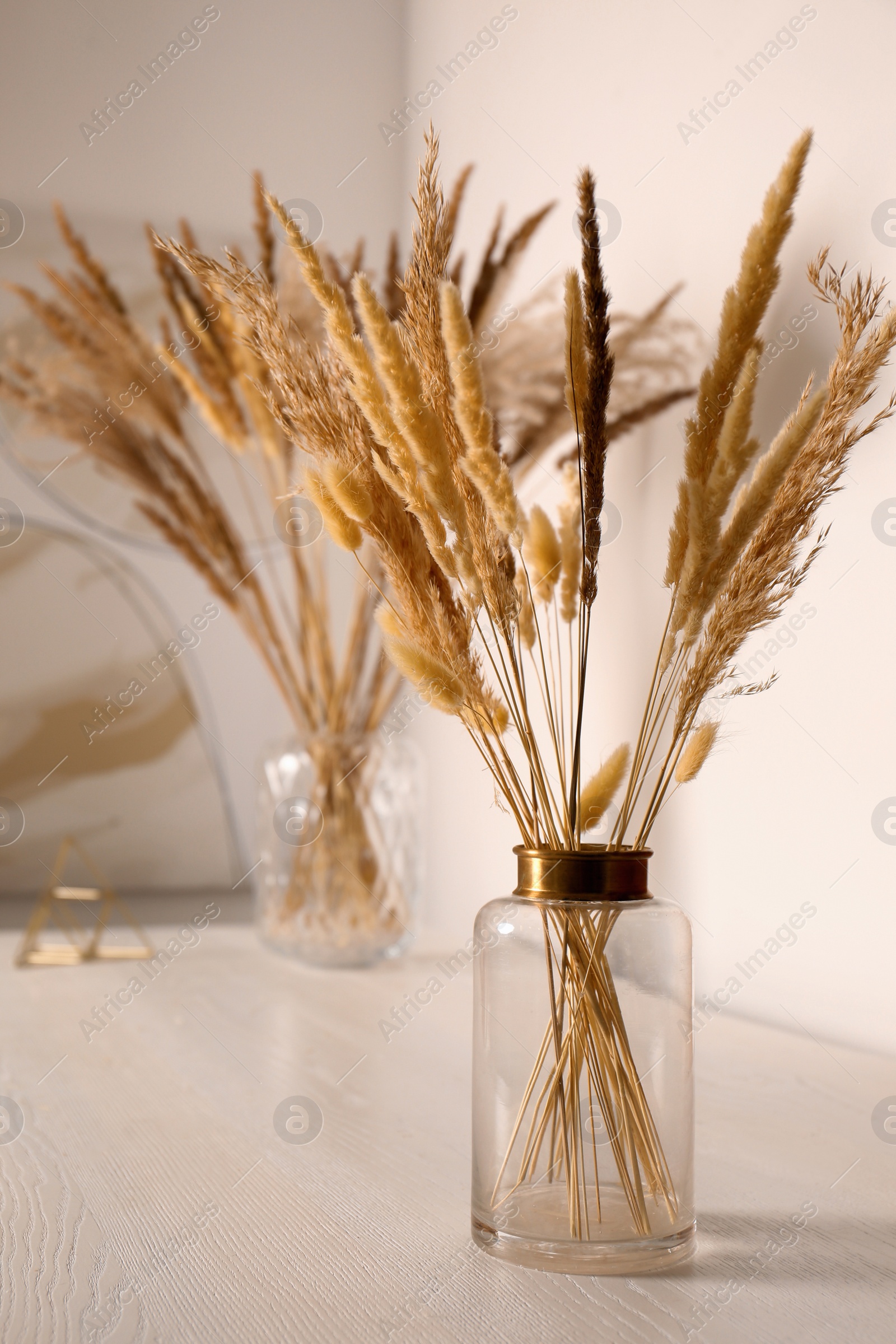 Photo of Dry plants on white table indoors. Interior design