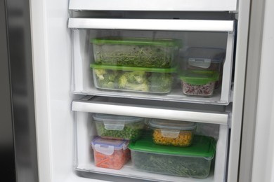 Plastic and glass containers with different fresh products in fridge. Food storage