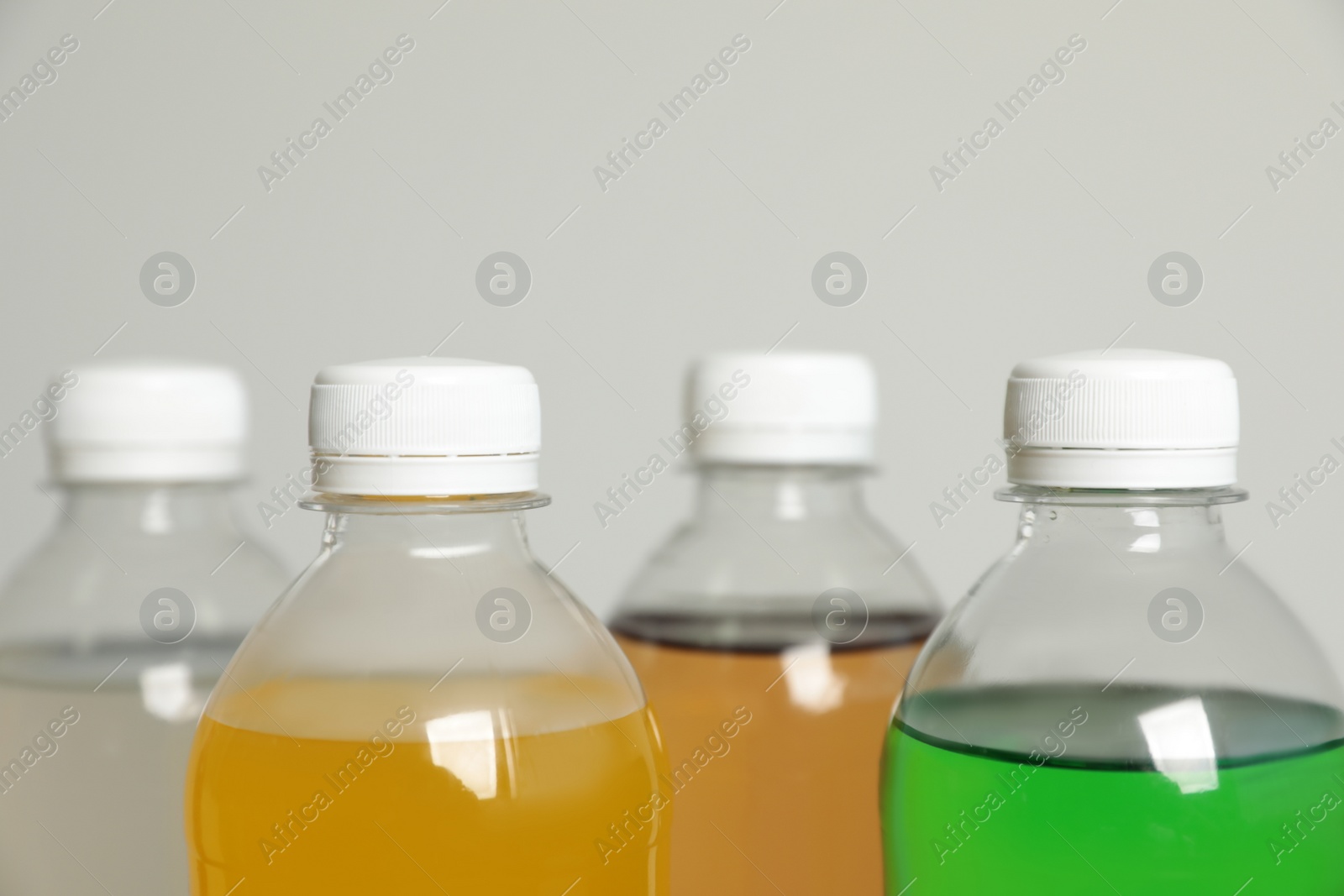 Photo of Bottles of soft drinks on grey background, closeup