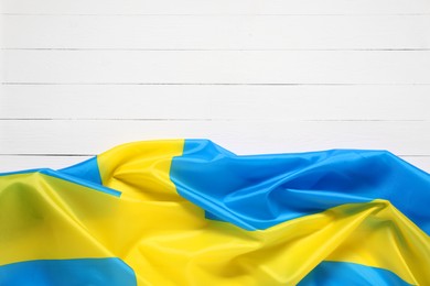 Photo of Flag of Sweden on white wooden background, top view. Space for text
