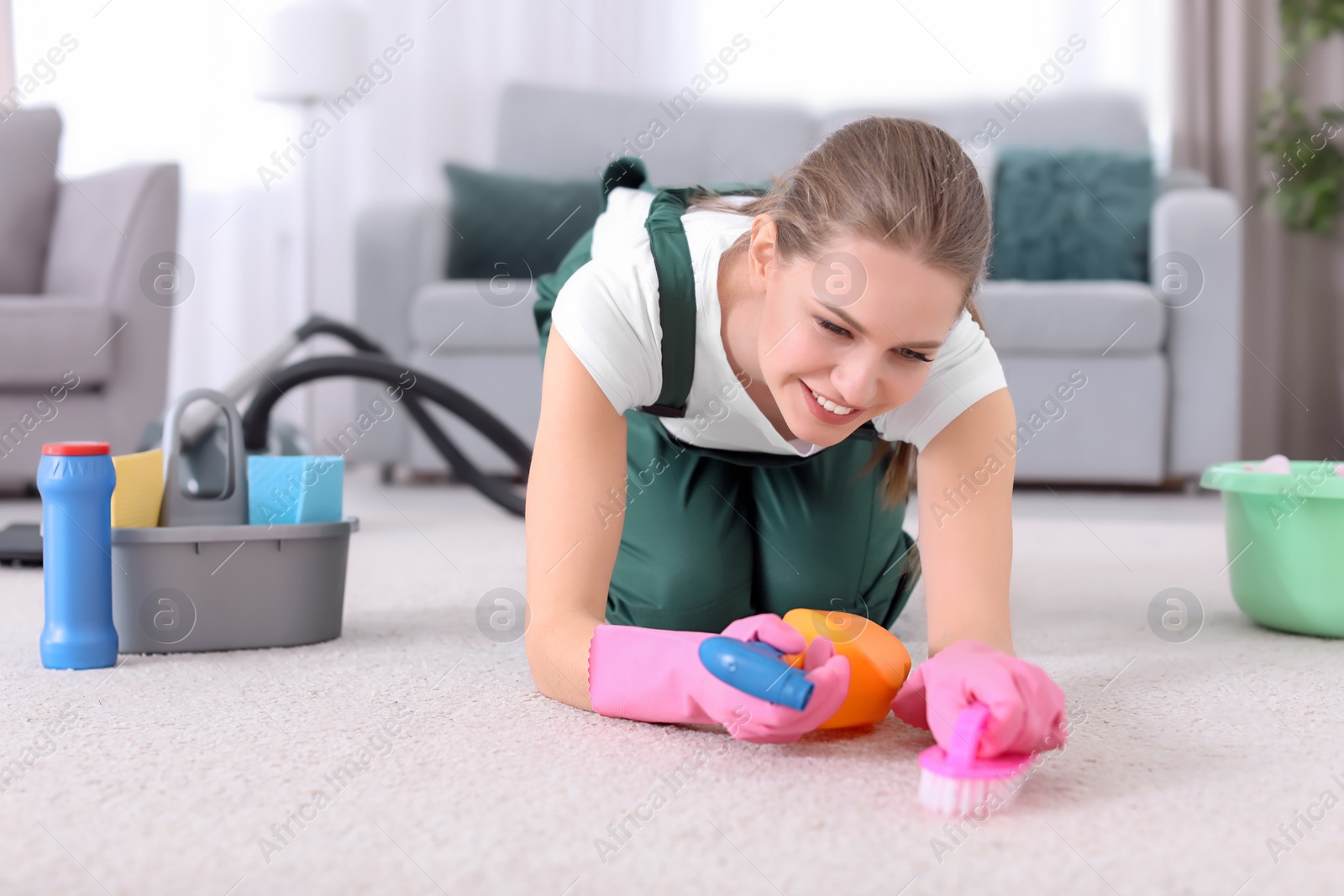 Photo of Female worker cleaning carpet at home