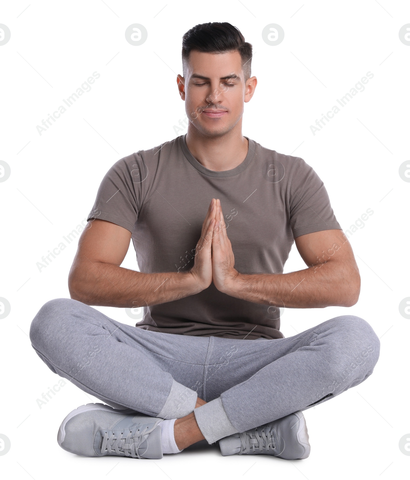 Photo of Handsome man meditating on white background. Harmony and zen