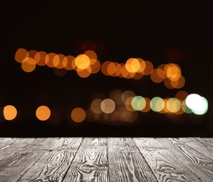 Image of Empty wooden surface against blurred lights. Bokeh effect 