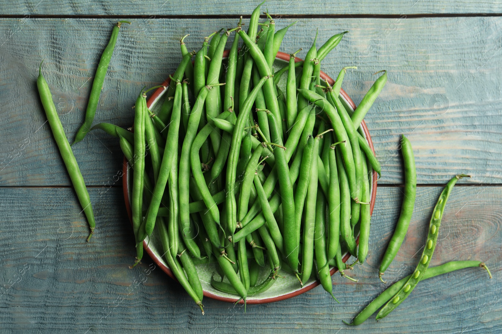 Photo of Fresh green beans on blue wooden table, flat lay