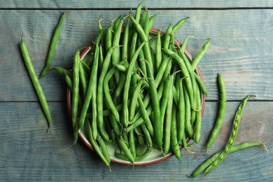 Photo of Fresh green beans on blue wooden table, flat lay