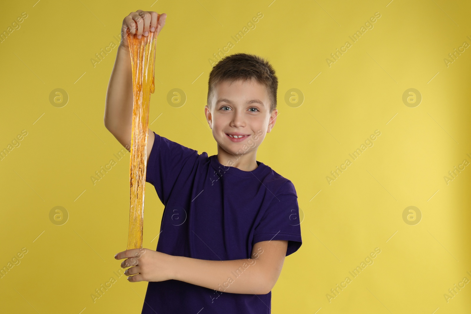 Photo of Little boy with slime on yellow background